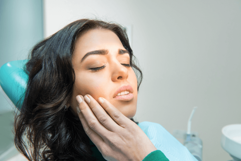 35 hispanic female dental pain exam holding jaw eyes closed 1.png