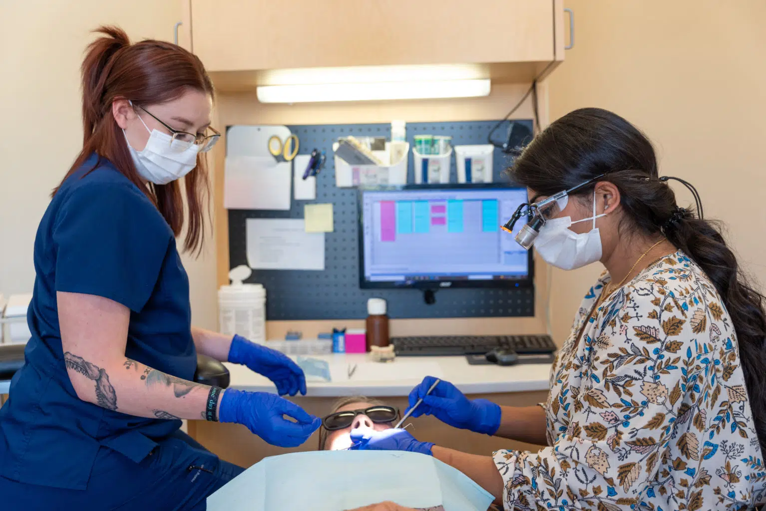 Dr Patel, experienced emergency dentist in Alvarado, treating a patient with her dental assistant